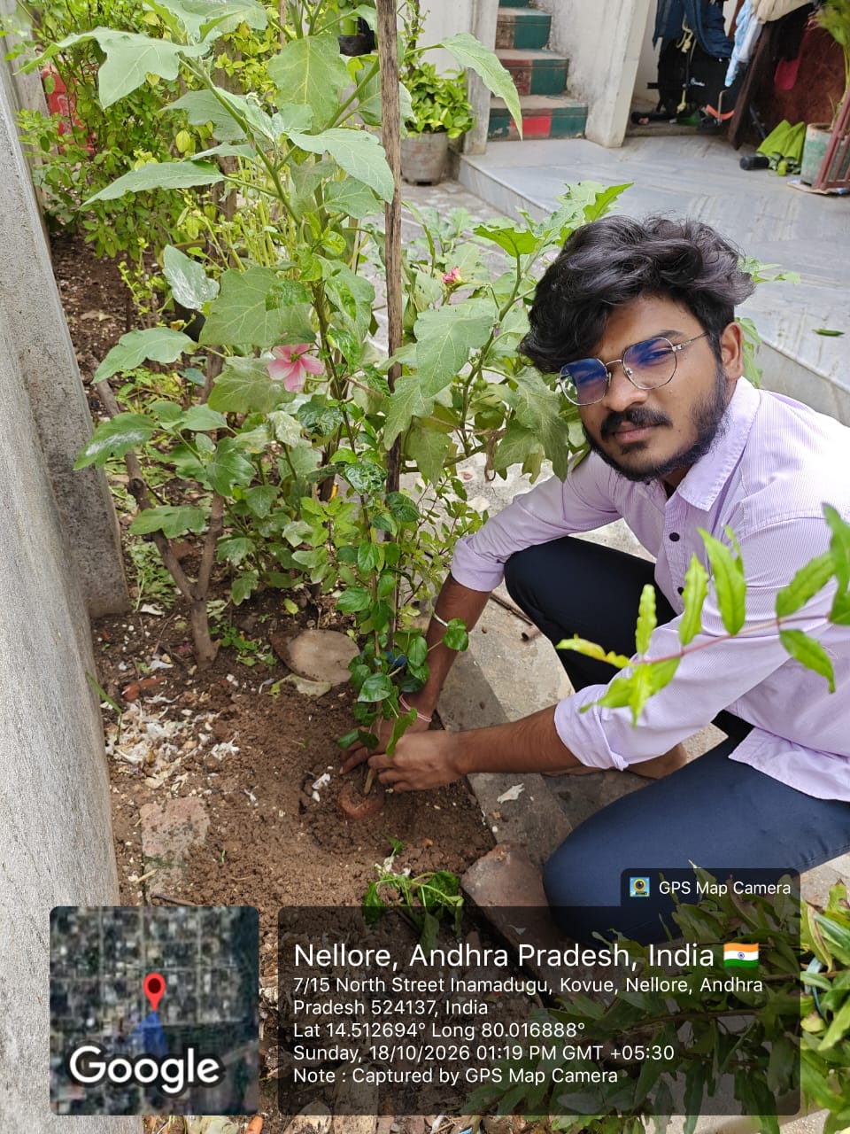 A student planting a sapling near the school building
